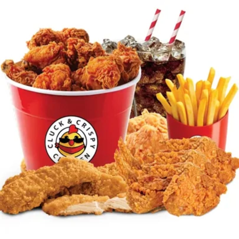 Cluck & Crispy Chicken bucket with fried chicken, fries, and two sodas with striped straws.